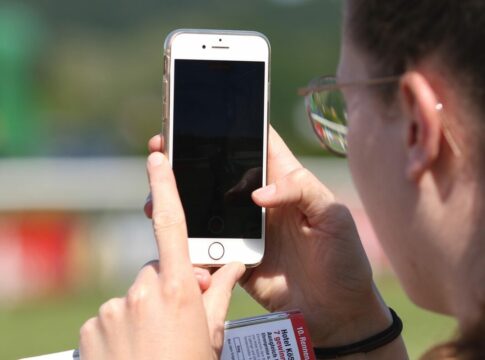 Ein Pferd wird mit dem iPhone im Absattelring fotografiert Handy